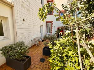 a patio with a bunch of plants next to a building at L'harmattan Studio T1 PREMIUM dans résidence Privée avec Patio à proximité in Saint-Nazaire