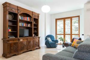 a living room with a large wooden entertainment center at Oasi di Famagosta Milano Navigli in Milan
