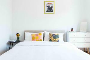 a bedroom with a white bed and a white dresser at Oasi di Famagosta Milano Navigli in Milan +28 photos