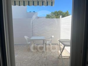 een tafel en stoelen op een terras met een hek bij Marks House - Spiaggia a 300m By Cala Salento in Porto Cesareo