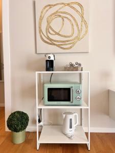 a white shelf with a microwave on top of it at Relax House CityCenter in Pescara