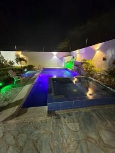 Una piscina de noche con luces violetas en Villa Isabel Casa Patio, en Ríohacha