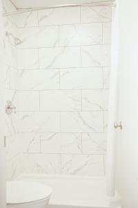 Un baño blanco con bañera y inodoro. en OYO hotel Greensboro east I 40, en Greensboro 64 fotos más