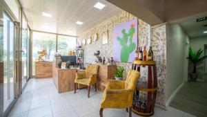 a restaurant with a bar with yellow chairs and bottles of wine at La Cactus Boutique Hotel in Antalya