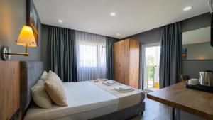 a bedroom with a large bed and a window at La Cactus Boutique Hotel in Antalya