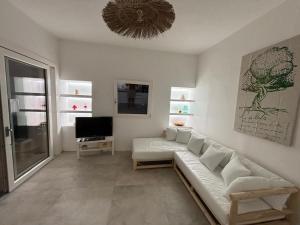 ein Wohnzimmer mit Sofa und Fernseher in der Unterkunft Casa Ulivo in Capilungo