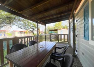 een houten tafel en stoelen op een veranda bij Del Falco AgriCamp-12 kilometers to Garda Lake and Verona in Bussolengo