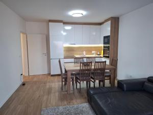 a kitchen and dining room with a table and chairs at Comfort Apartment 3 in Ferizaj +9 photos