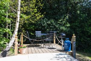 a deck with a grill and a blue fire hydrant at Yurt with Hot Tub near Hartington, Peak District in Buxton