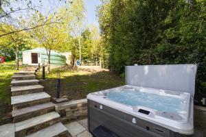a hot tub sitting in a yard with stairs at Yurt with Hot Tub near Hartington, Peak District in Buxton
