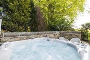 a jacuzzi tub in a backyard with trees at Yurt with Hot Tub near Hartington, Peak District in Buxton