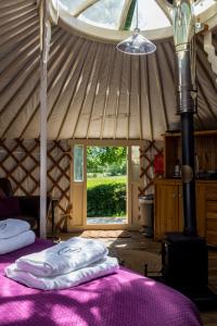 a room with a bed in a yurt with a window at Yurt with Hot Tub near Hartington, Peak District in Buxton