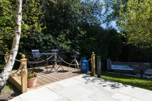 a wooden deck with a table and a blue gas can at Yurt with Hot Tub near Hartington, Peak District in Buxton