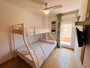 a bedroom with two bunk beds and a ceiling fan at Punta Cormoran by Alina365 in La Manga del Mar Menor +75 photos