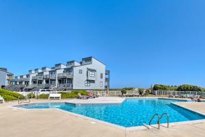 una piscina frente a un gran edificio de apartamentos en N Topsail Beach Oceanfront Condo with Pool!, en North Topsail Beach