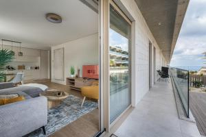 a living room with a bed and a balcony at GuestReady - Bright & Inviting Stay in Vila Nova de Gaia