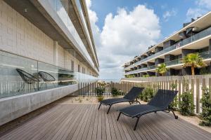 two chairs sitting on a deck next to a building at GuestReady - Bright & Inviting Stay in Vila Nova de Gaia