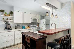 a kitchen with white cabinets and a wooden counter top at Big Island Fairway Terrace A-202 by Coldwell Banker Island Vacations in Waikoloa Village