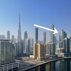 una vista dello skyline di una città con una freccia bianca di Canal Luxe Burj 1BR Sleeps 4 with Pool and Gym a Dubai