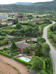 une vue aérienne sur une maison et une route dans l'établissement Era de Cal Baro - Casa rural con gran piscina y jardin, à Collfred