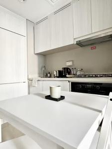 una cucina con armadi bianchi e piano di lavoro bianco di Canal Luxe Burj 1BR Sleeps 4 with Pool and Gym a Dubai