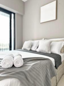 una camera da letto con un letto con asciugamani sopra di Canal Luxe Burj 1BR Sleeps 4 with Pool and Gym a Dubai Altre 42 foto