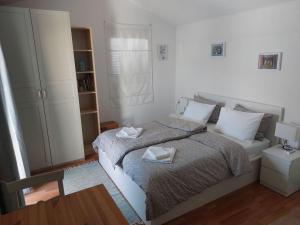 House Valun 42 في فالون: غرفة نوم بيضاء مع سرير وطاولة