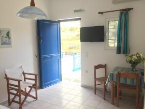 a dining room with a blue door and a table and chairs at Μαρίνα 2 in Agios Ioannis
