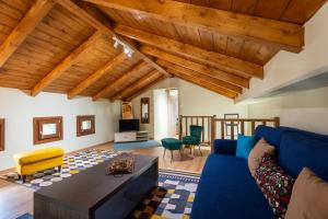 ein Wohnzimmer mit einem blauen Sofa und einem Tisch in der Unterkunft Wooden Villa in Agria