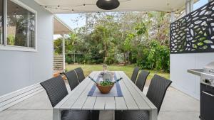a table with chairs and a bowl of fruit on it at Sam's Beach Shack and Apartment in Callala Beach