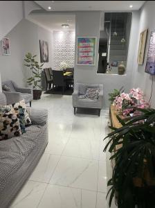 a living room with couches and a dining room at Casa da Lu - Aconchego Baiano in Salvador