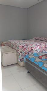 a bed with a comforter on top of it at Casa da Lu - Aconchego Baiano in Salvador