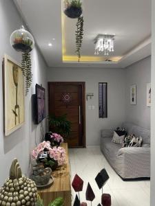 a living room with a couch and a table with flowers at Casa da Lu - Aconchego Baiano in Salvador +24 photos