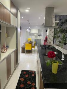 a kitchen with a black counter top and a table at Casa da Lu - Aconchego Baiano in Salvador