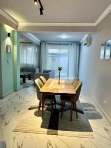 uma sala de jantar com mesa e cadeiras de madeira em 3-Bedroom Duplex Apt em Dar es Salaam