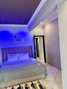 um quarto com uma cama com um tecto roxo em 3-Bedroom Duplex Apt em Dar es Salaam
