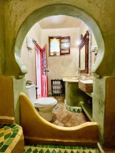 a bathroom with a toilet and a sink and a tub at Dar Meziana in Chefchaouen