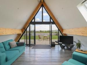 a living room with glass doors and a tv at Kerry Hill - The Sheepfold in Llandrindod Wells