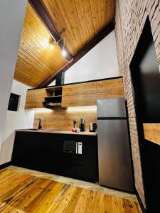 a kitchen with a stainless steel refrigerator and wooden ceilings at Ler House Dilijan in Dilijan