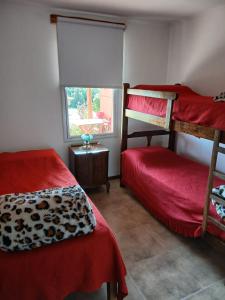 Un dormitorio con dos literas y una ventana. en Cabañas Rincon de Campo San Andres De Las Sierras, en Villa Ventana