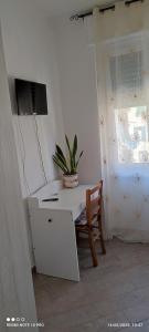 een wit bureau met een stoel en een plant erop bij Stephy Holiday Station 5 Terre in La Spezia