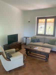 a living room with a couch and a coffee table at Vitabella Toscana in Seggiano
