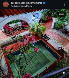 einen kleinen Pool in einem Garten mit Blumen in der Unterkunft Casa Paula Acosta in Rodadero