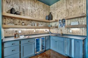 a kitchen with blue cabinets and wooden walls at Nashville Studio B Suite 4BR by Maddox Hotel in Nashville