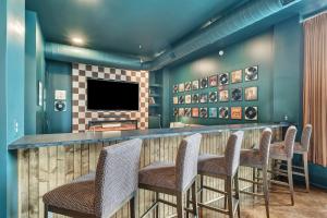 a bar with chairs and a flat screen tv at Nashville Studio B Suite 4BR by Maddox Hotel in Nashville