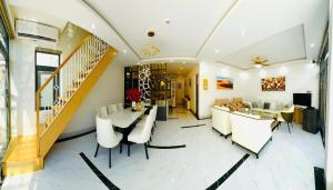 a dining room with white chairs and a table at My Trang Homestay in Ấp Bình Hưng +6 photos