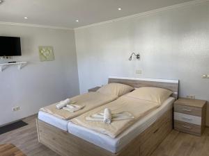 a bedroom with a large bed with towels on it at Pension Weiß in Zinnowitz
