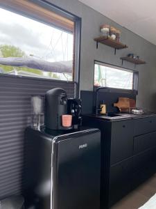 una cucina con piano cottura e frigorifero. di Hotelkamer op water Houseboat Wetterhûske Friesland a Suameer