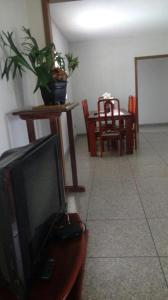 a living room with a tv and a table with a dining room at Sítio Rodrigues in Pedro Leopoldo