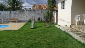 a yard with chairs and a fence and a house at Sítio Rodrigues in Pedro Leopoldo